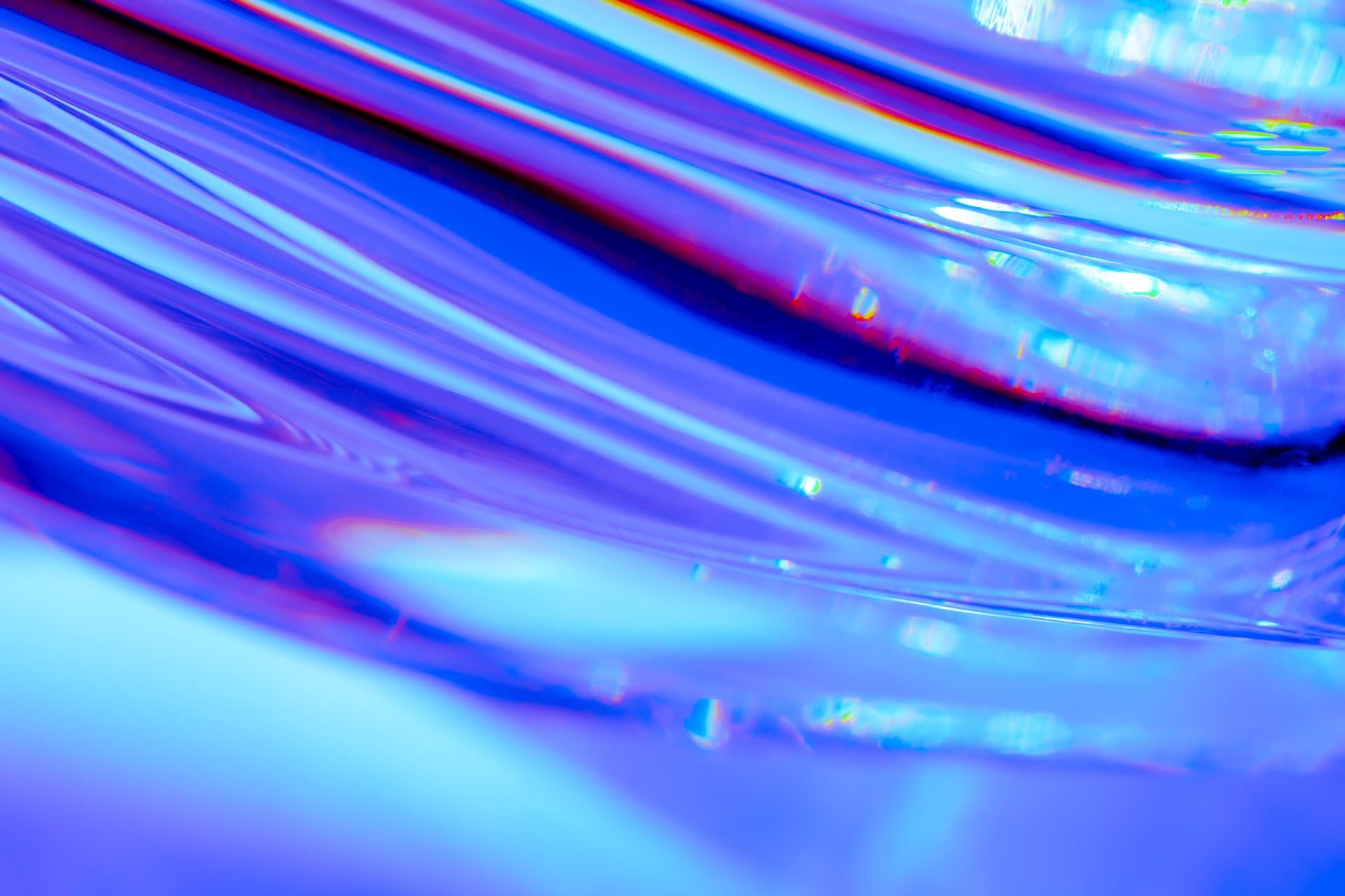 Abstract blue and violet light refraction through glass, creating a calming wave-like pattern for healthcare wellness imagery.